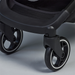 Close-up of a black stroller wheel on a gray background