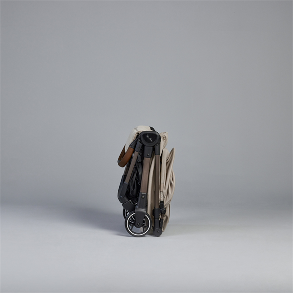 Folded baby stroller on a gray background