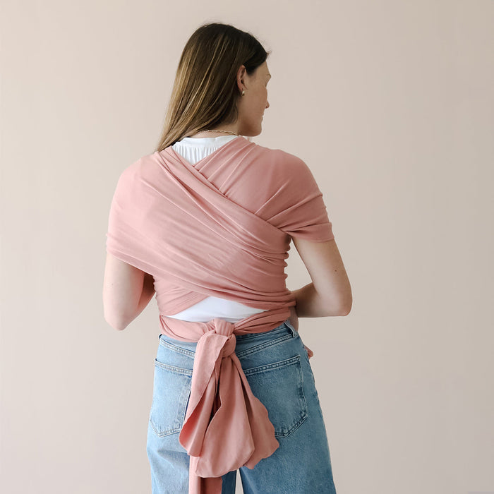 Woman wearing a pink wrap over her shoulders against a plain background