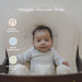 Baby in a snuggle me lounger mat with text 'Snuggle. Discover. Grow.' featuring organic cotton toys, parent friendly set up and developmental support