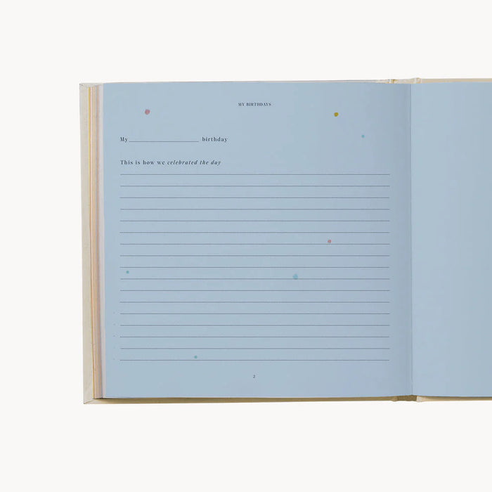 Open keepsake birthday book for journal style entry shown on blue paper