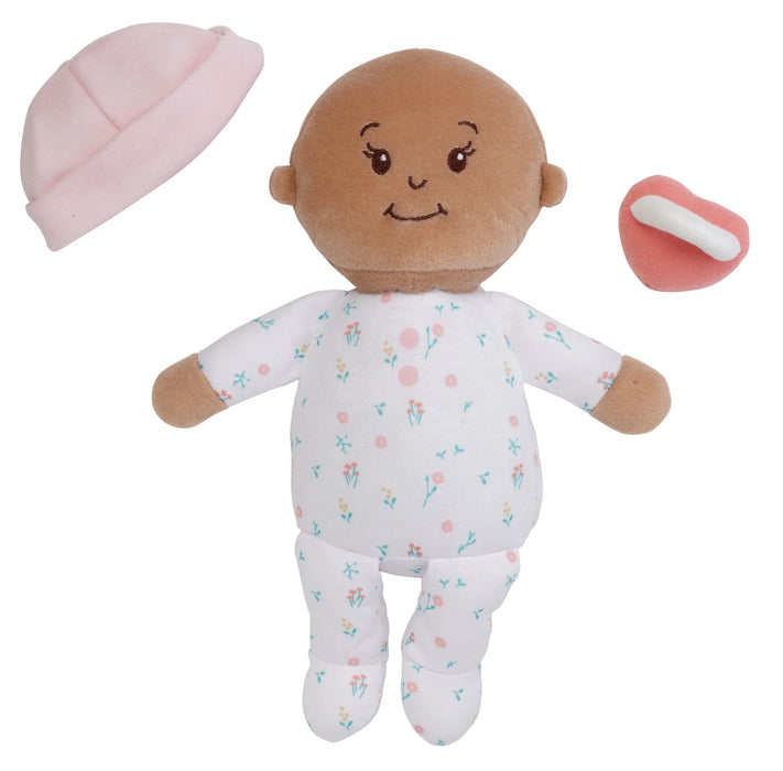 Plush baby doll with a pink hat and pacifier on a white background