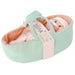 Mint green baby carrier with pink interior containing a baby doll, branded 'Love, Stella'.