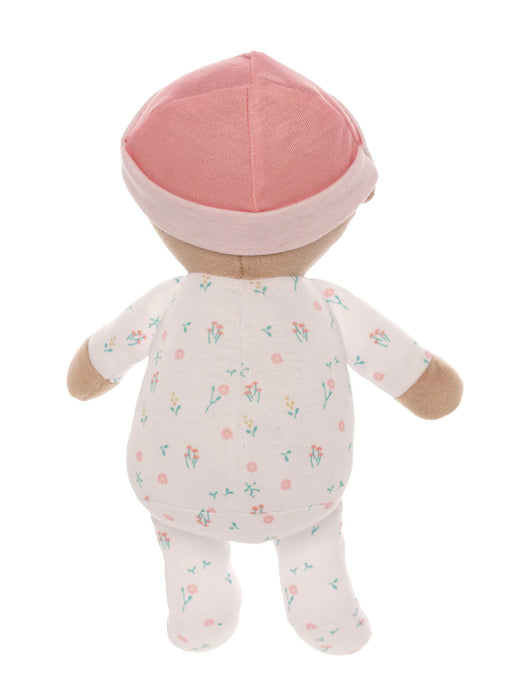 Stuffed toy baby in a floral onesie and pink cap on a white background