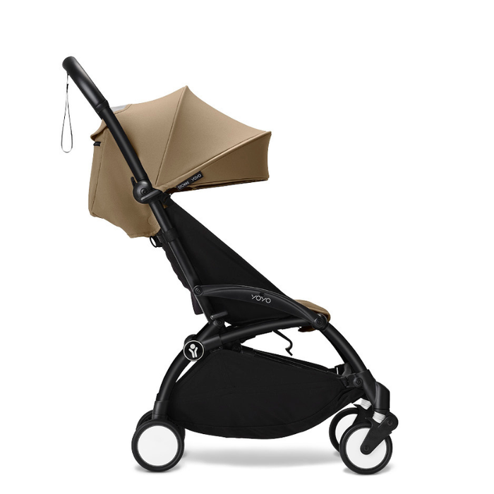 Black and beige travel stroller on a white background