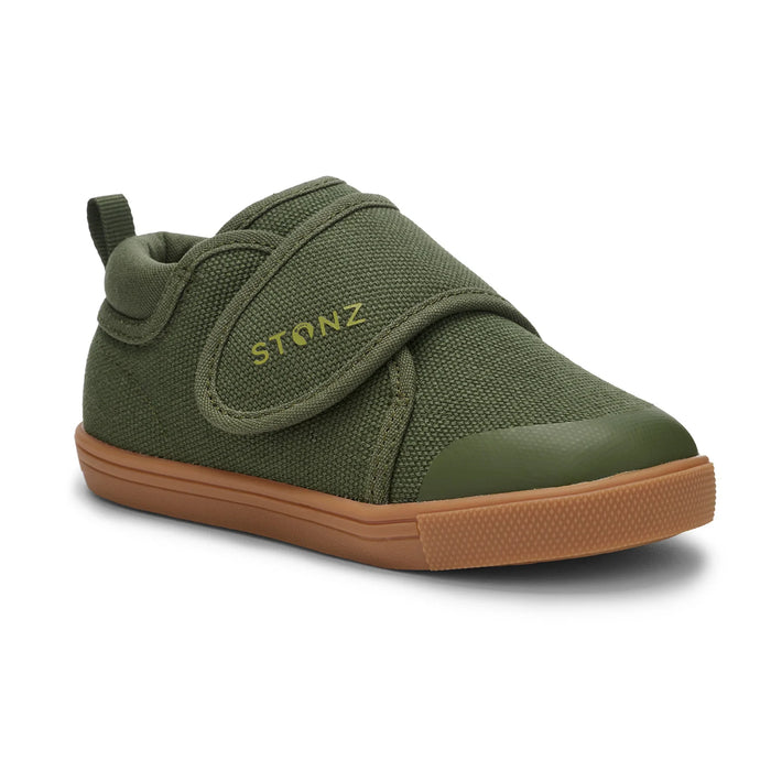 Green children's shoe with brown rubber sole on a white background