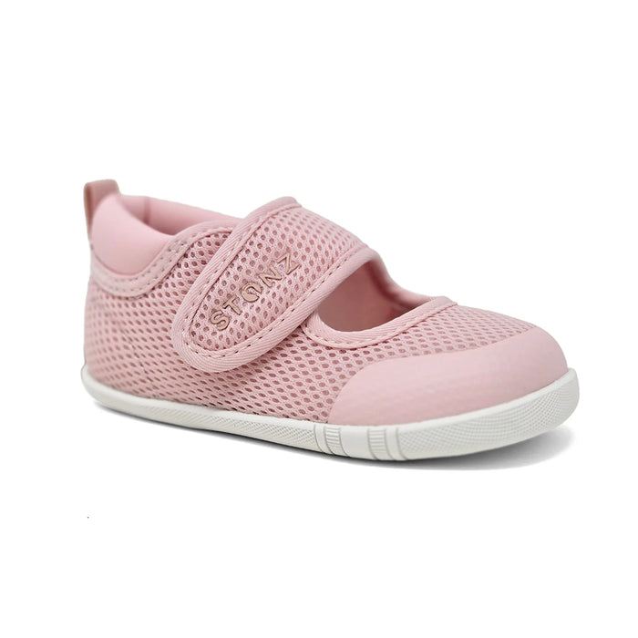 Pink children's shoe with a white sole on a white background