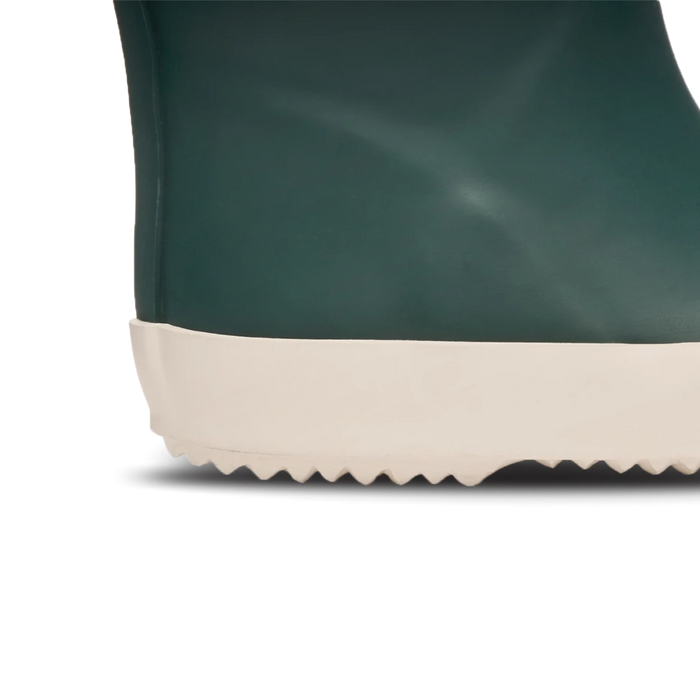 Close-up of a green rain boot with a white sole on a white background