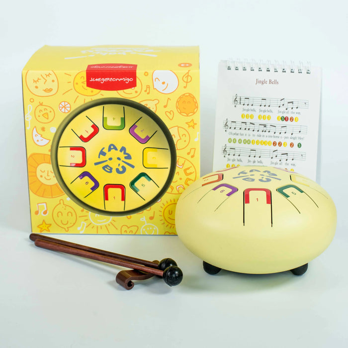 Children's musical instrument with colorful designs, packaging, and music sheet on a white background