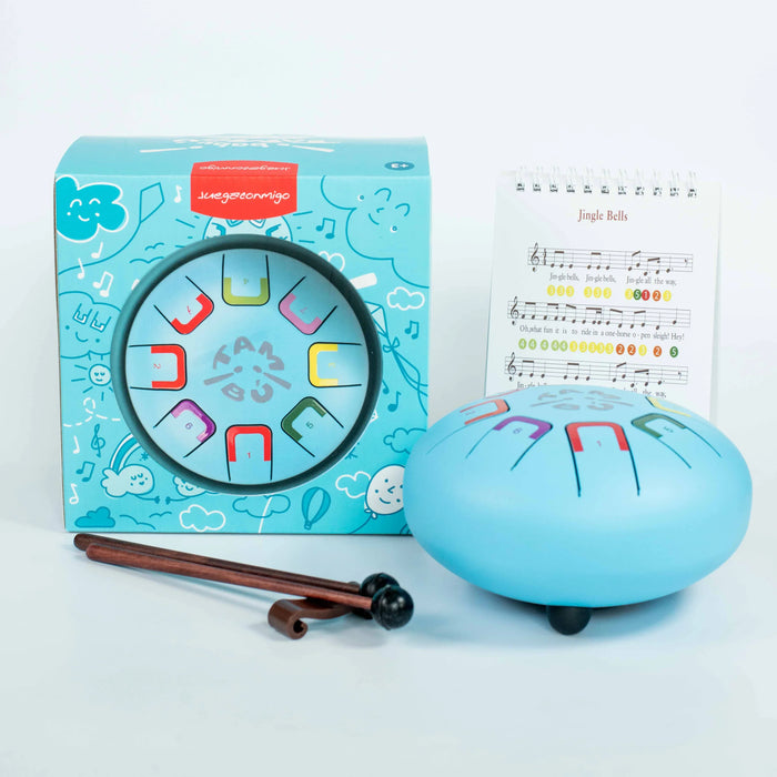Blue jingle bell with colorful designs, packaging, and music sheet on a white background
