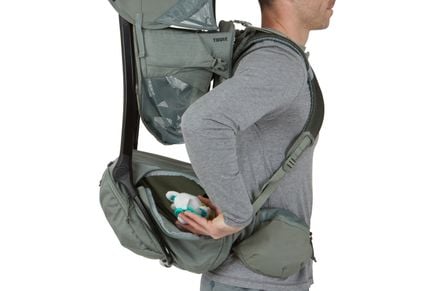 Person wearing a green hiking backpack with a white background