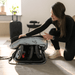 Woman assembling a stroller into a travel bag in a home setting