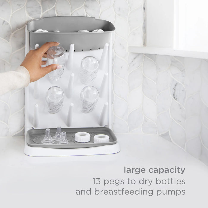 Gray drying rack with bottles and breast pumps on a white background