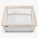 Beige baby playard with white mattress on a white background