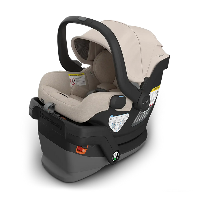 Baby car seat with beige interior and black exterior on a white background