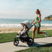 Woman running with a stroller on a beachside path