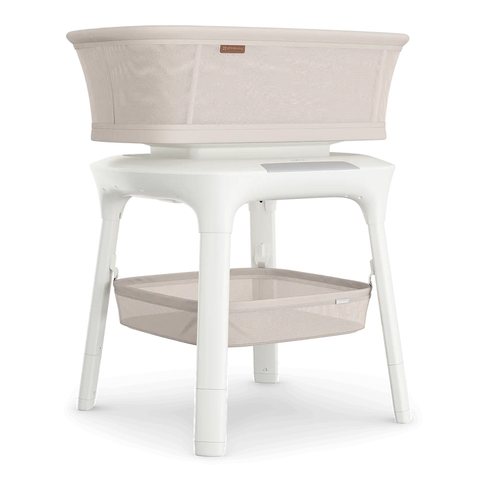 White bassinet with beige fabric on a white background