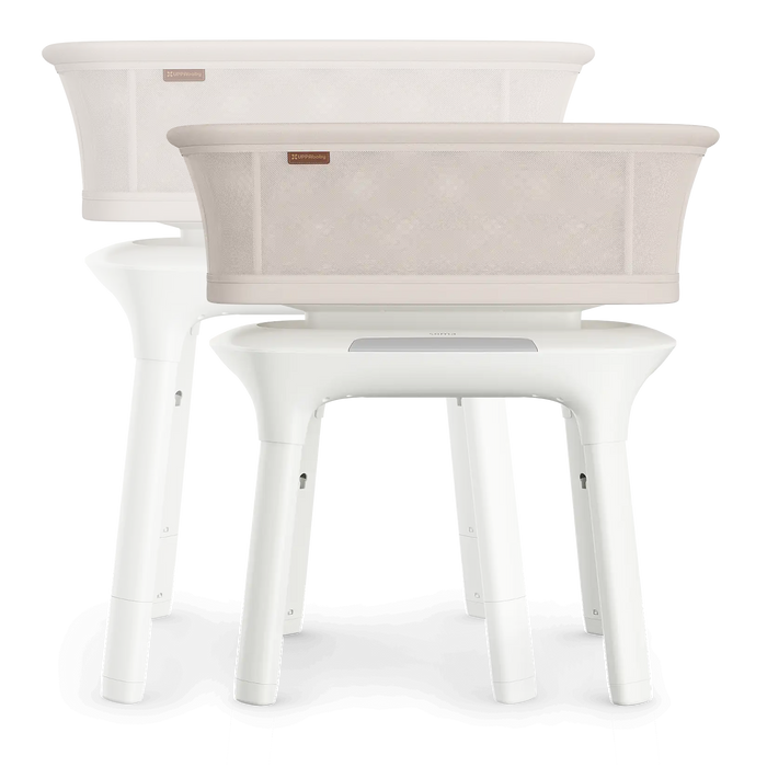 White baby bassinet with beige fabric on a white background