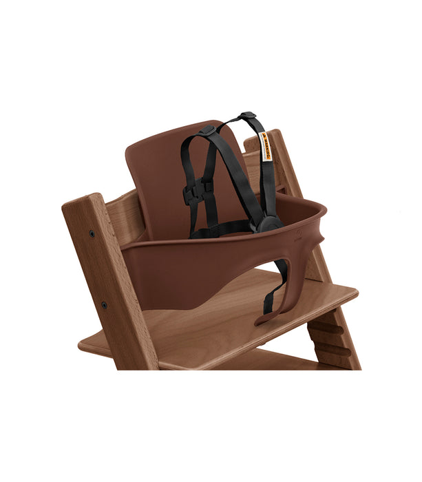 Brown high chair with harness on a white background