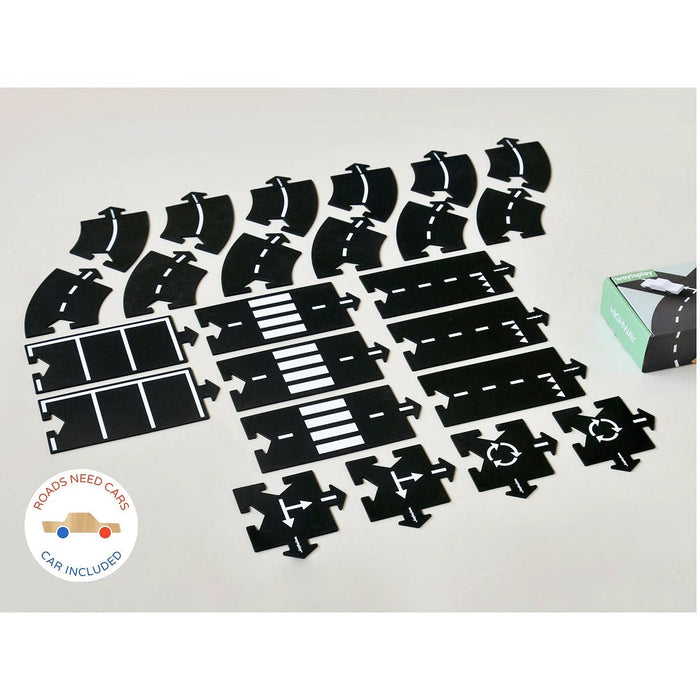 Black toy car track pieces on a white surface with a small green box in the corner.