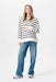 Woman wearing a black and white striped shirt and blue jeans on a white background