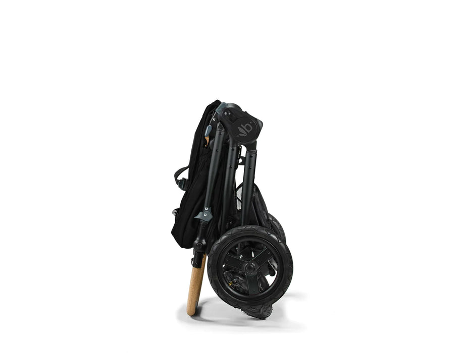 The Bumbleride Era Stroller shown folded compactly into itself and standing upright. Wheels and handlebar stabilize