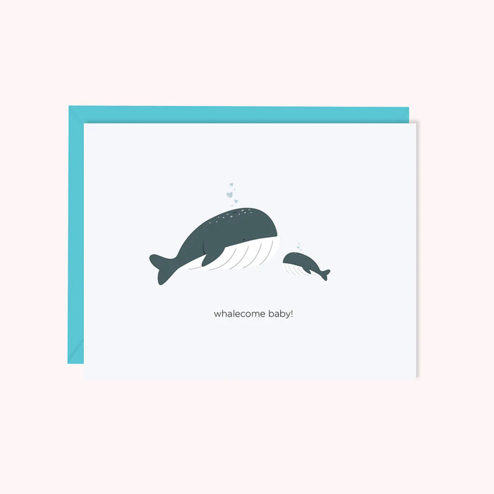 A large whale and a baby size whale feature hears blowing out of their blowholes and caption reads "Whalecome Baby" original design by Halifax Paper Hearts