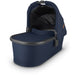 caption-Noa Uppababy bassinet for stroller use in deep navy blue fabric on canopy and body of bassinet plus zippered overlay. Black metal framing to coordinate with stroller frame is exposed at upper part of bassinet