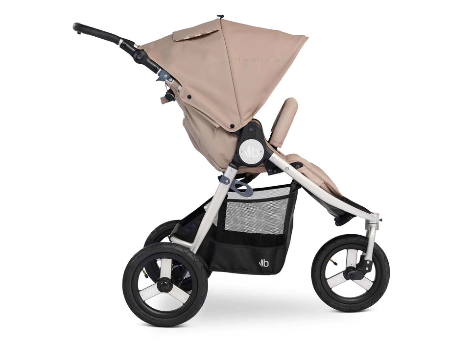 Side profile of bumbleride indie with 3  large air filled wheels, roomy basket and silver frame with sand canopy and seat. 
