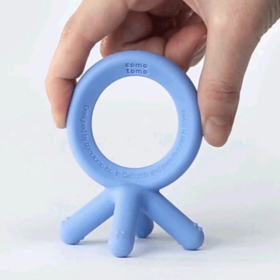 Flexible with just a gentle squeeze the blue comotomo teether is shown flexing and bending. Babies love being able to handle and manipulate this lightweight teether