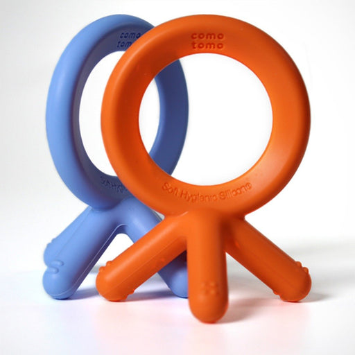 Como Tomo Teether in orange and blue silicone. The circle shape allows baby to teethe and use motor skills with their tongue. The fingers of the teether feature sensory bumps that help massage gums